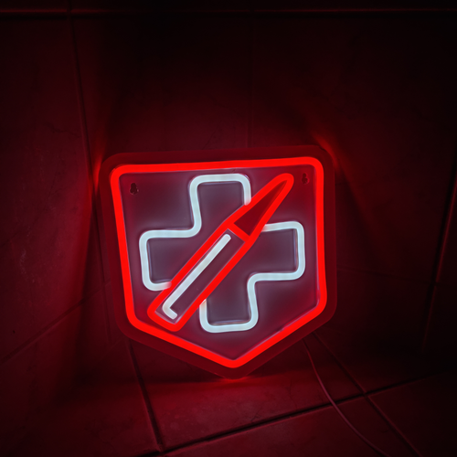 Close-up side angle of the Call of Duty Juggernog perk neon sign glowing red and white mounted on a dark wall in a gaming room setup